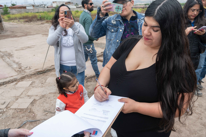 Familias firmando el acta de entrega de terreno del conjunto Los Naranjos en San Bernardo
